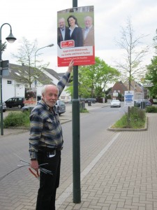 Ingo Stolz hängt Wahlplakate für Ina Grothe auf